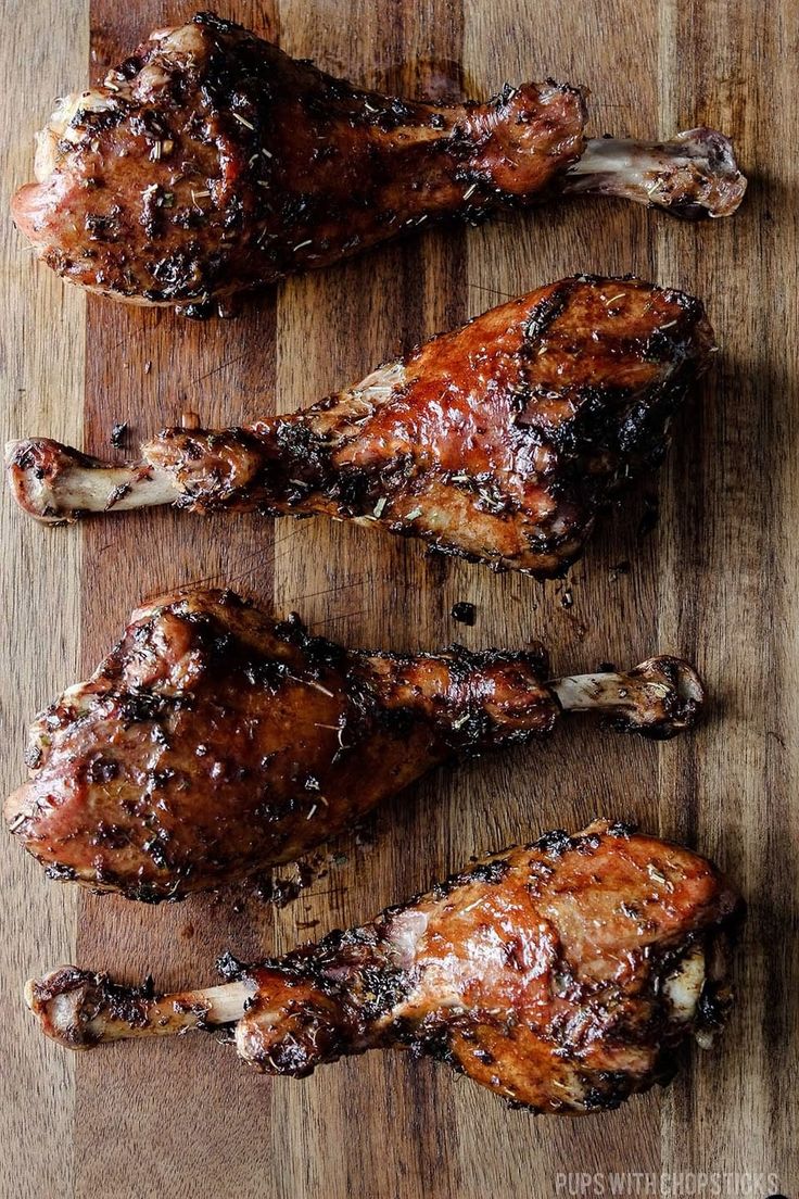 three pieces of meat sitting on top of a wooden cutting board next to each other