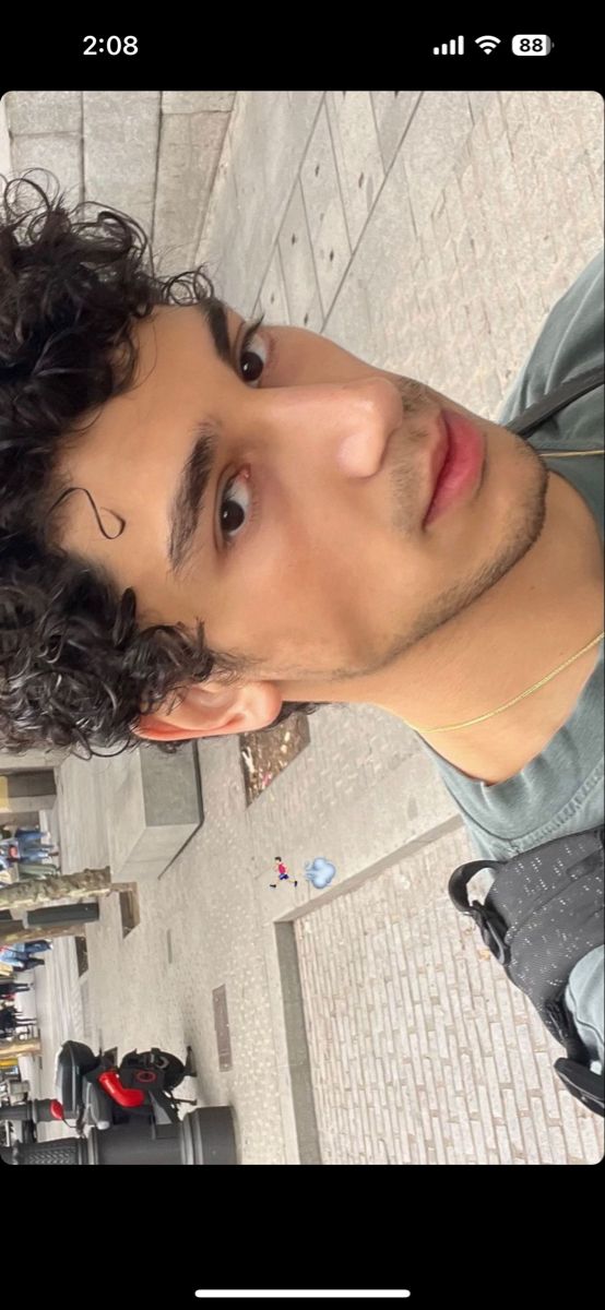 a man with curly hair is looking up at the camera