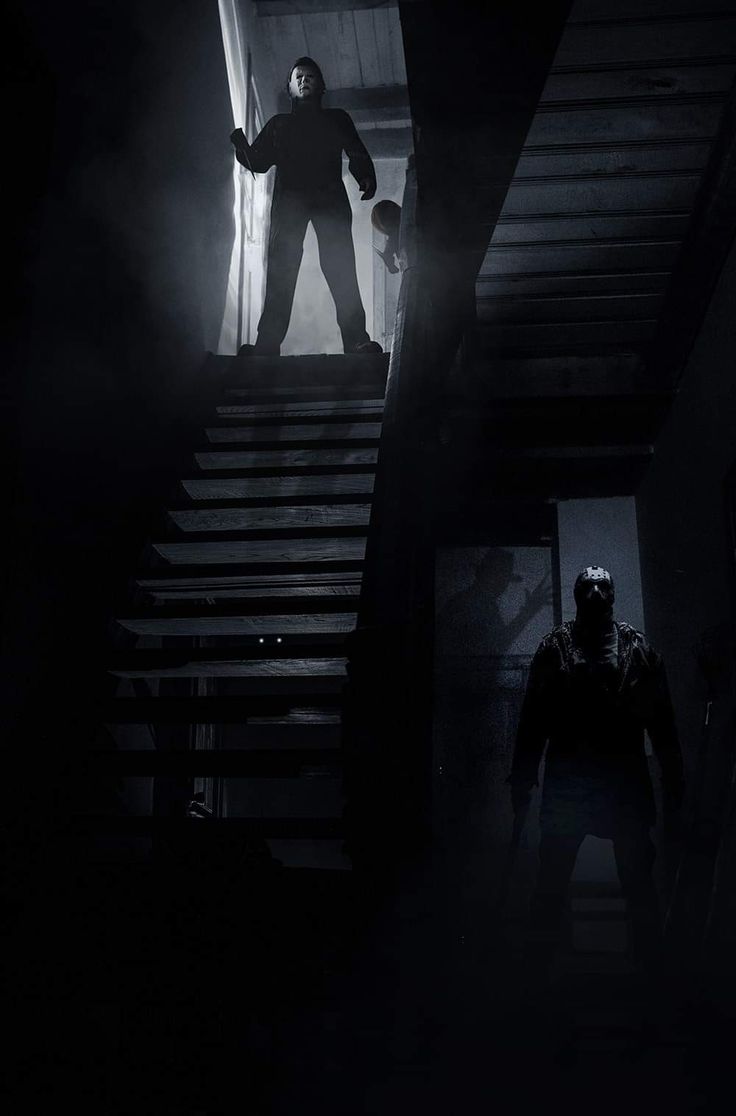 a man standing on top of a set of stairs next to a person in a dark room