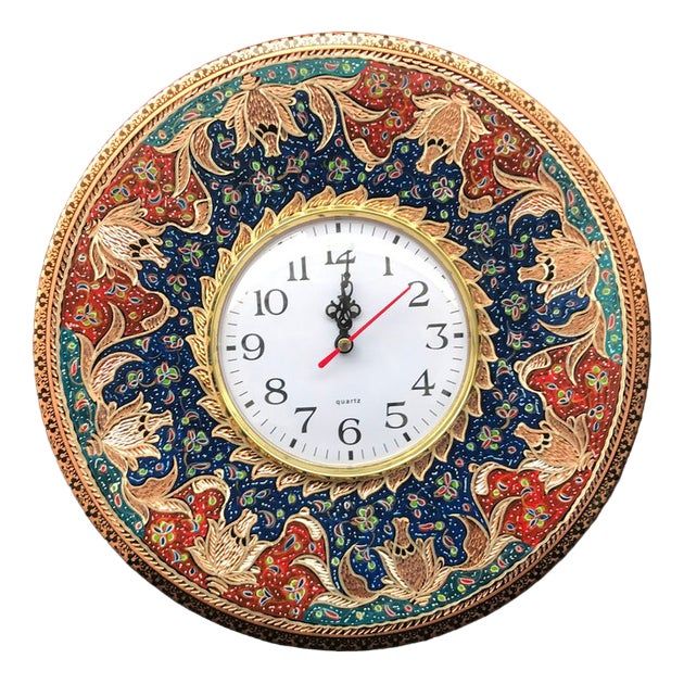 a clock with an intricate design on the face and hands is shown in gold, blue, red, and green