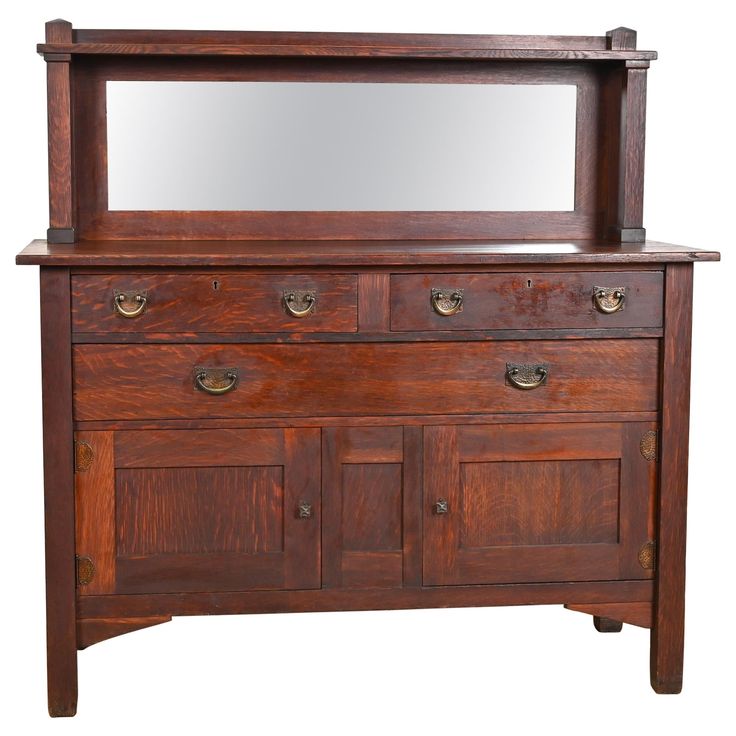 an old wooden dresser with mirror on it's top and drawers below the shelf