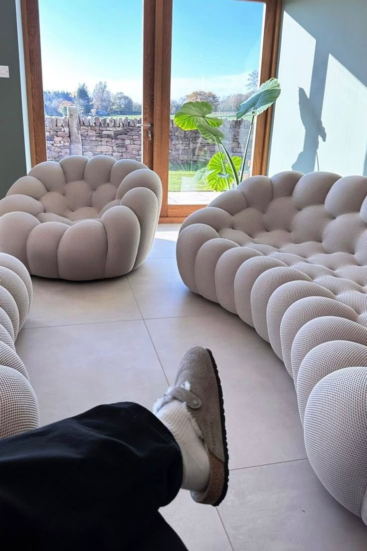 a person laying on the floor with their feet up in front of some couches