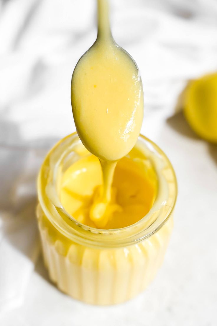 a spoon full of honey sitting on top of a jar