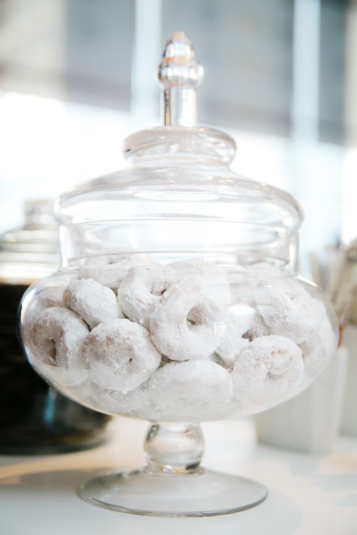 a glass container filled with sugar covered donuts