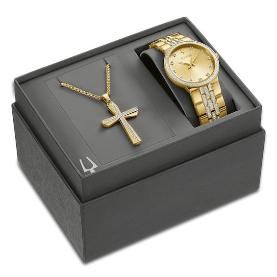 Perfect for gift-giving, this men's boxed set from Bulova showcases a men's watch from the Crystals collection that has sparkling clear crystals on the gold-tone stainless steel bracelet, bezel and the champagne dial. A mineral crystal tops the 40mm stainless steel case, which is water-resistant to 30 meters. The watch features a quartz movement and secures with a push button fold over clasp. A coordinating cross necklace with crystal center is included with the set. Timeless Gold Watch Accessories As A Gift, Classic Yellow Gold Diamond Watch Gift, Modern Gold Watch Accessories For Gifts, Classic Yellow Gold Diamond Watch As Gift, Modern Gold Watch Accessories As Gift, Modern Yellow Gold Watch Accessories As Gift, Yellow Gold Jewelry With Diamond Hour Markers For Gift, Yellow Gold Jewelry With Diamond Hour Markers As Gift, Yellow Gold Watches With Diamond Hour Markers As Gift