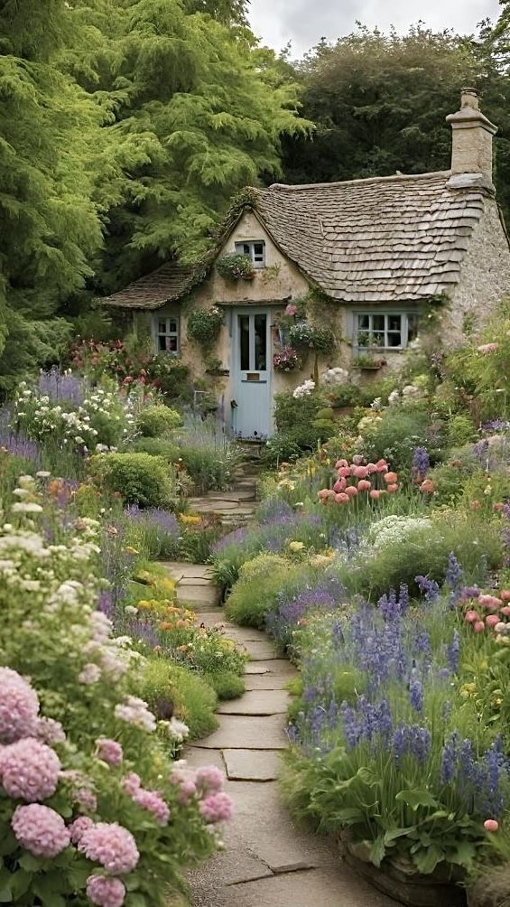 a stone house surrounded by flowers and greenery in the country side garden, with a pathway leading to it