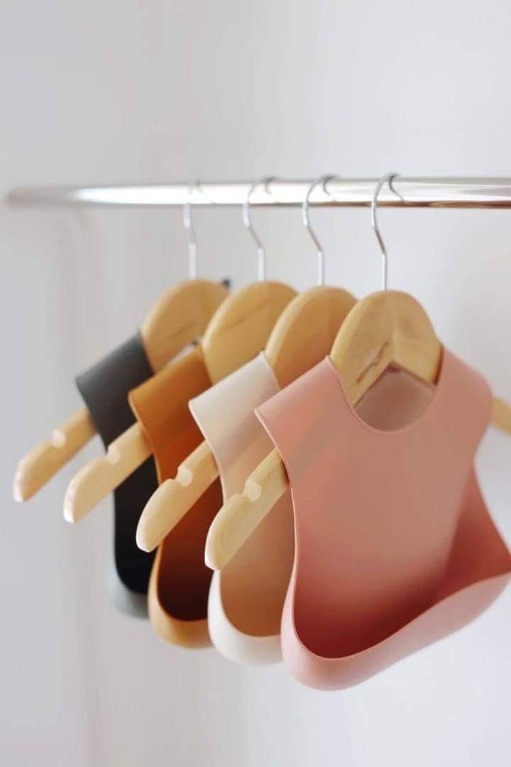 several bibs hanging on a rack in a room