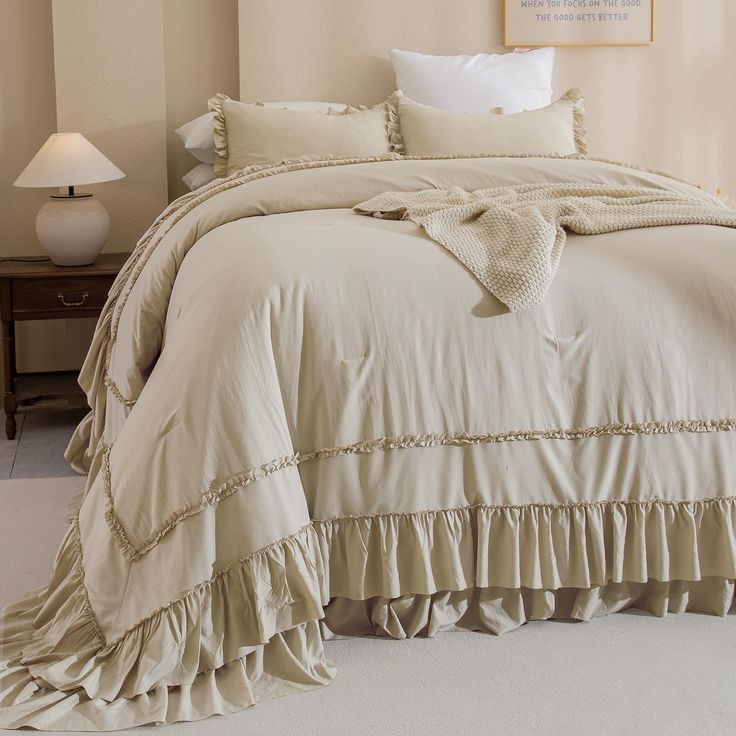 a bed with ruffled bedspread and pillows