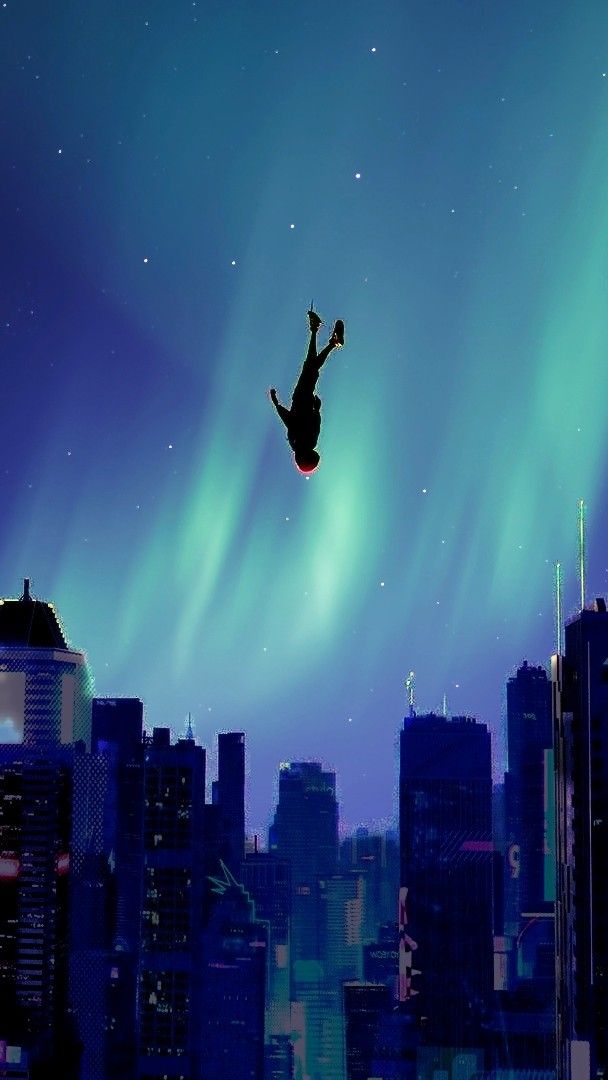 a man flying through the air while riding a snowboard in front of a city skyline