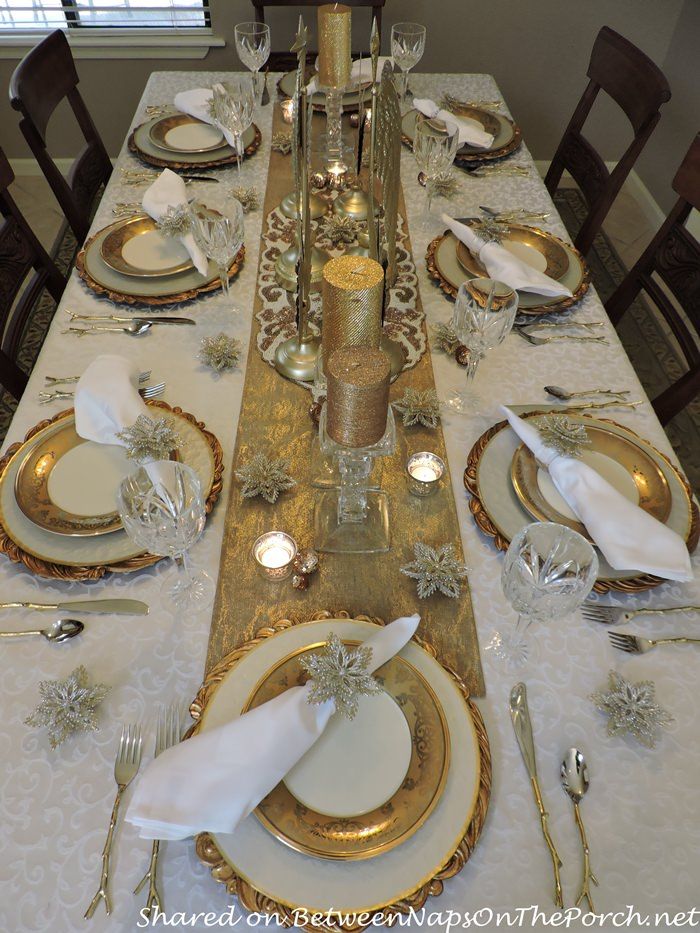 the table is set with white and gold plates