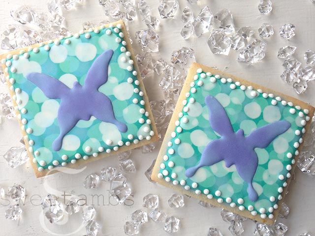 two decorated cookies sitting on top of a table