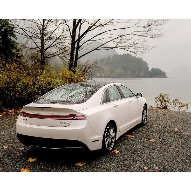 a white car parked next to a body of water