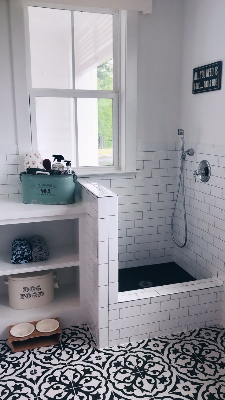 a white bathroom with black and white tile on the floor next to a bathtub