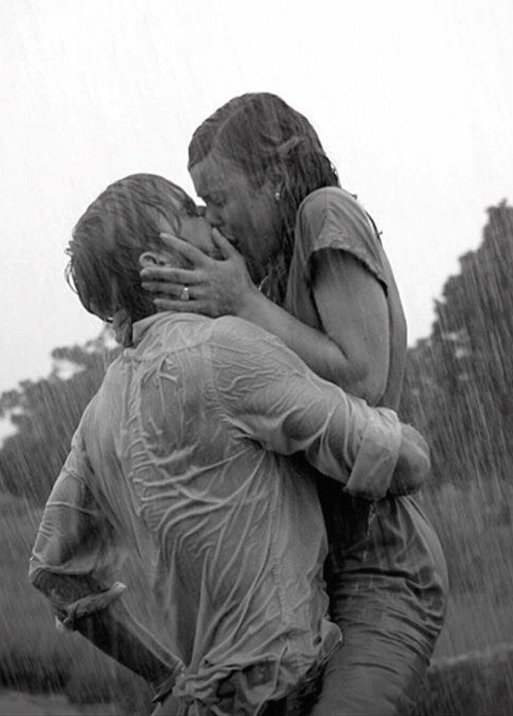 two people hugging each other in the rain