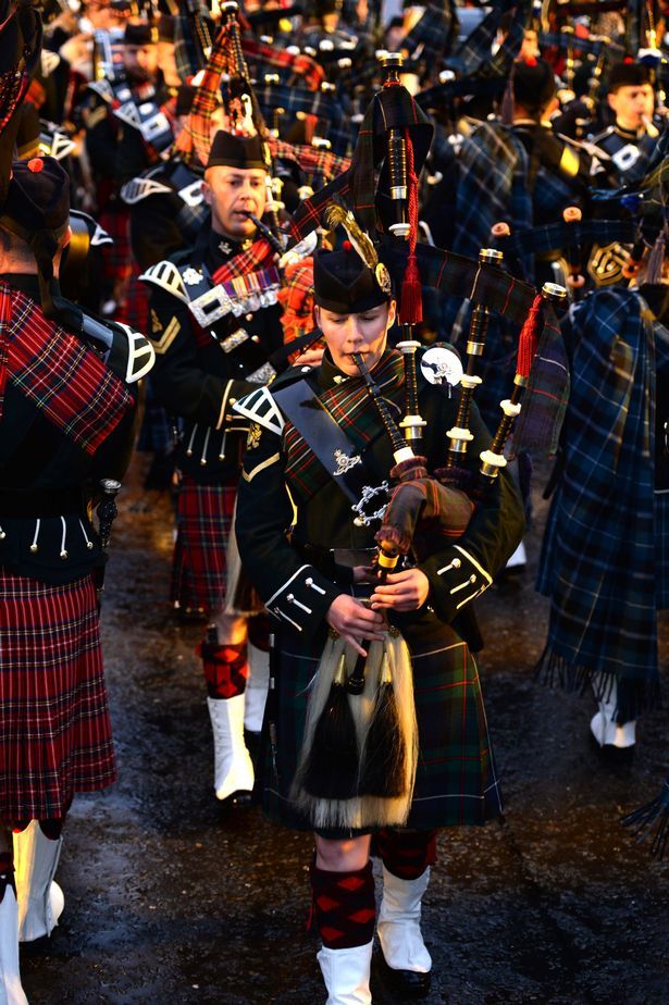 a group of men in kilts marching down a street