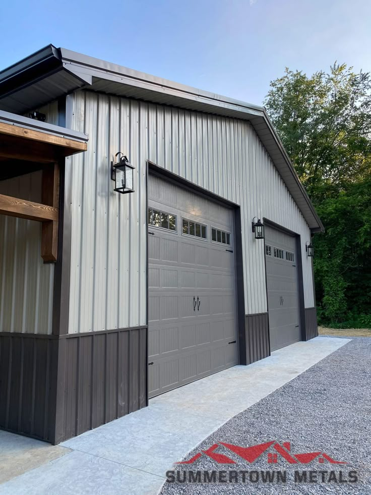 two garages in front of a metal building with windows and doors on each side