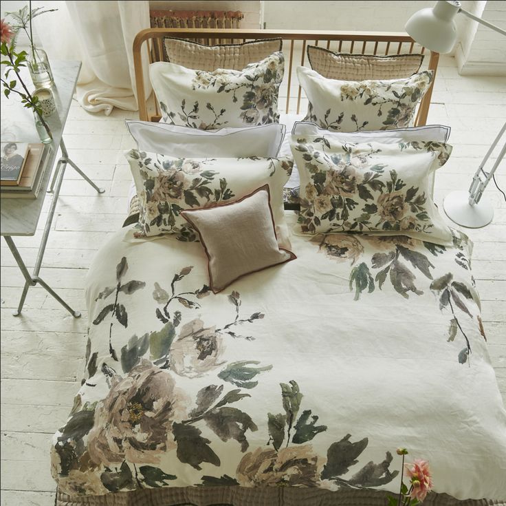 a bed with flowers on it in a room next to a table and chairs,