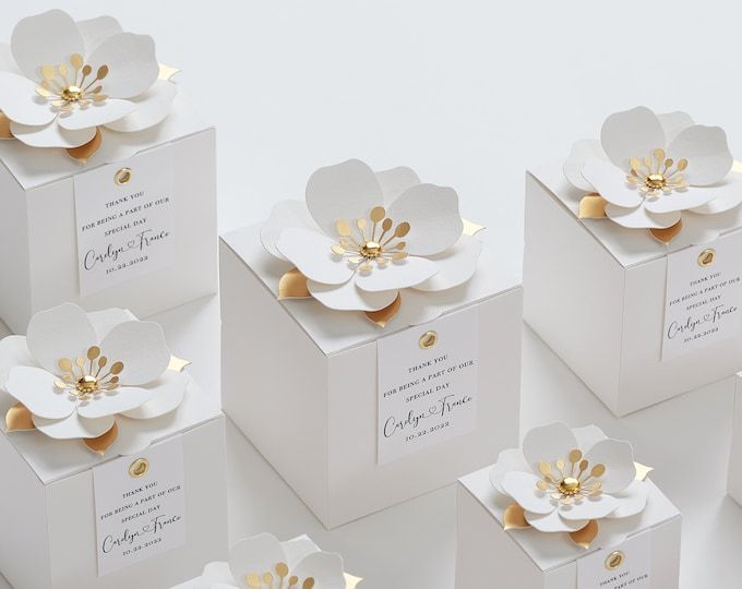 six white boxes with gold flowers on them