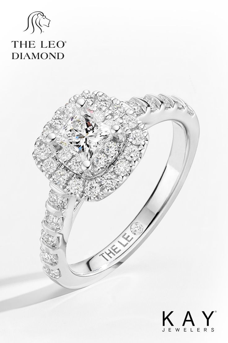 a white gold engagement ring with diamonds on the band and an oval center stone surrounded by round