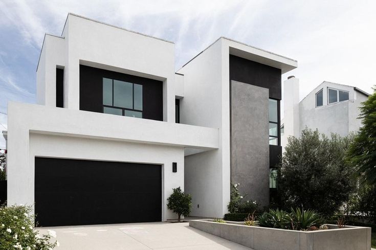 a large white house with black garage doors