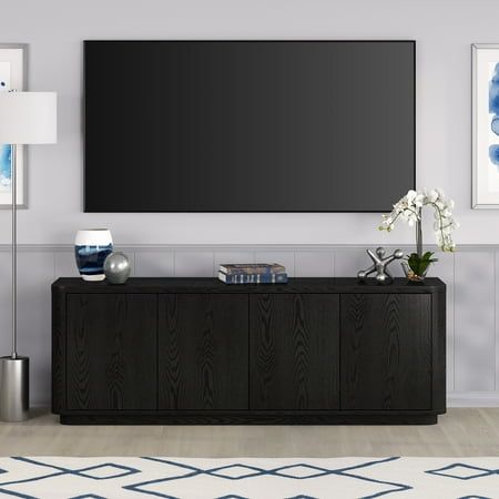 On-trend shape and design combine in this 68" TV stand. With a wood grain finish and sleek flush doors, this piece is sure to be a statement in your living room, den, or game room. The plinth base gives an illusion of a seamless transition from your floor, while the rounded front corners create a softer modern shape. The console features 4 inner shelves with cable management cutouts, allowing for ample storage and organization of your devices, games, books, and more. Size: 68" W x 15.5" D x 24" Black Media Console, Transitional Tv Stand, Tv Console Modern, Black Tv Stand, Flush Doors, Entertainment Center Decor, Tommy Bahama Furniture, Living Room Tv Stand, Tv Stands And Entertainment Centers