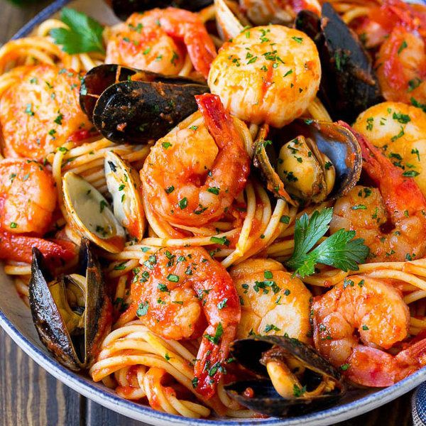 seafood pasta with clams and mussels in a skillet on a wooden table