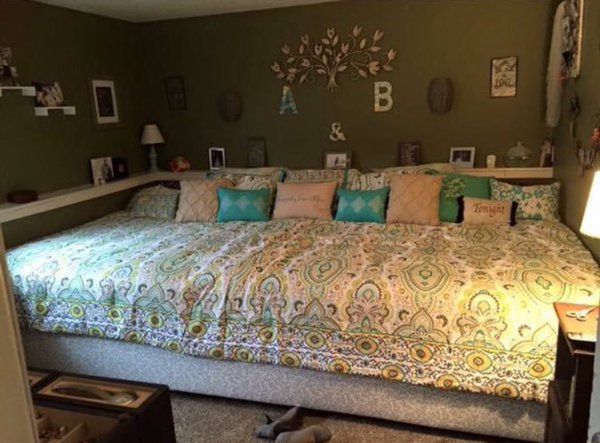 a large bed sitting in the middle of a bedroom next to a dresser and lamp