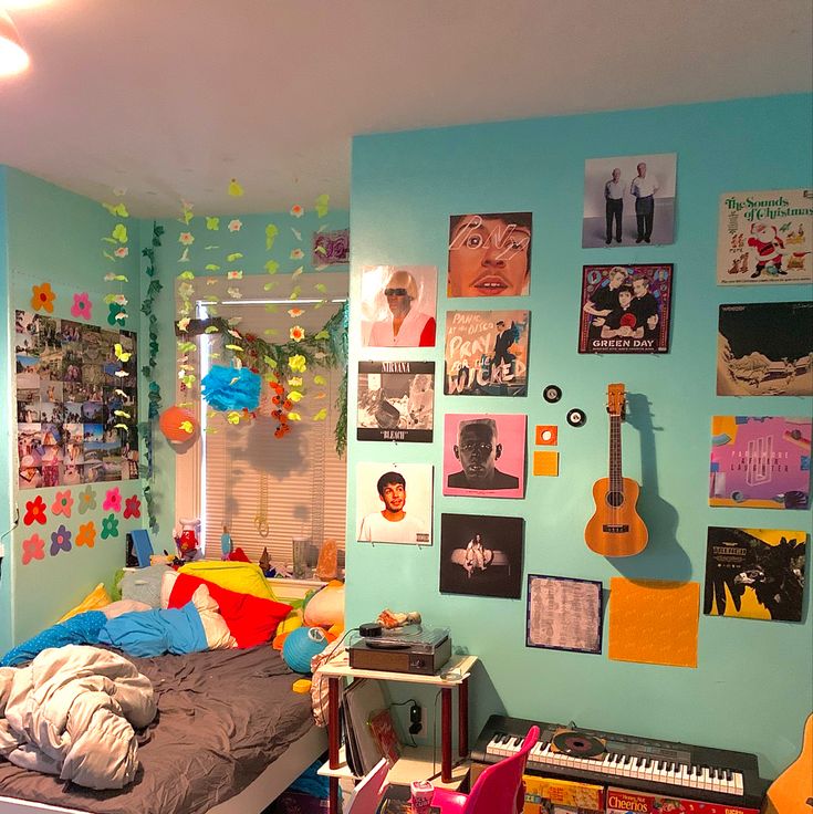 a bedroom with blue walls and lots of pictures on the wall, including a guitar