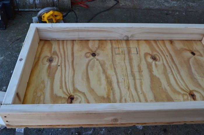 an unfinished wooden box sitting on the ground