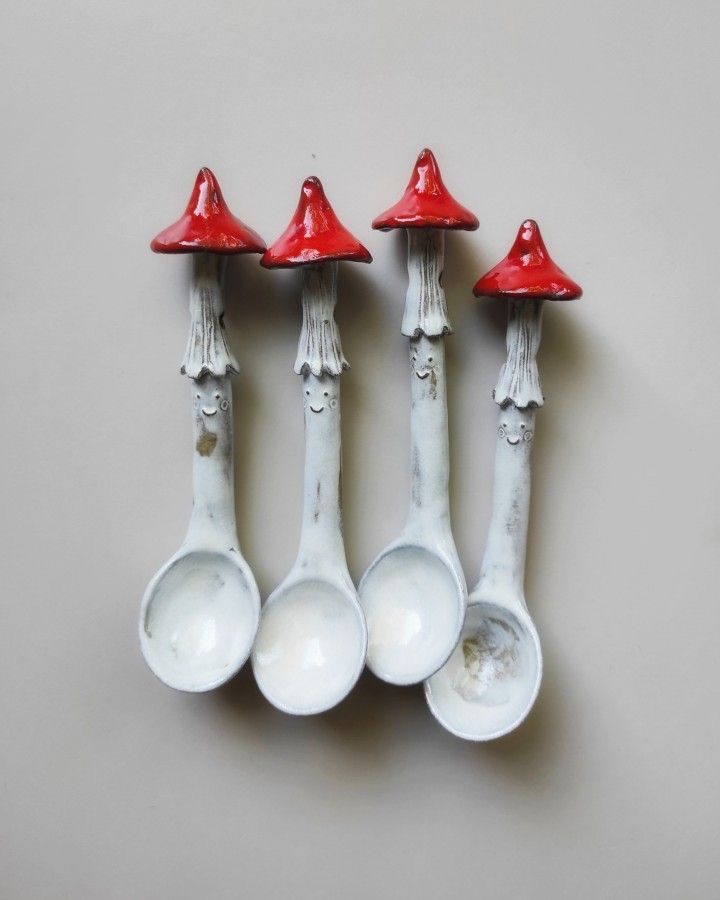 four spoons with red caps on them are lined up