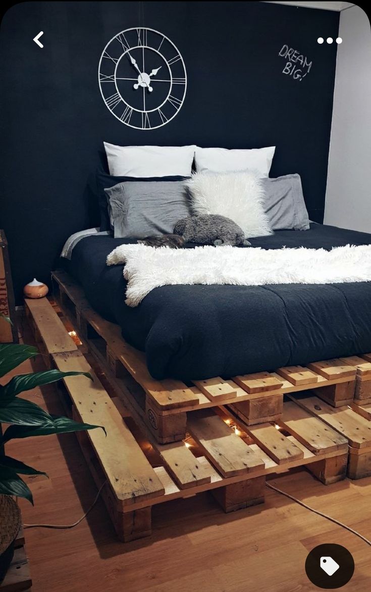 a bed made out of wooden pallets with a cat laying on top of it