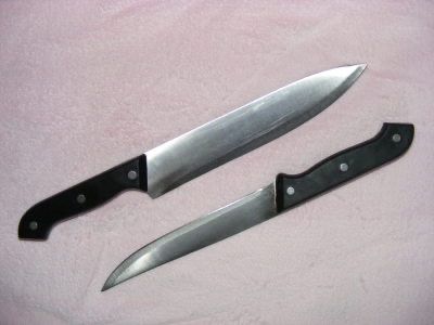 two knives laying next to each other on a pink blanket