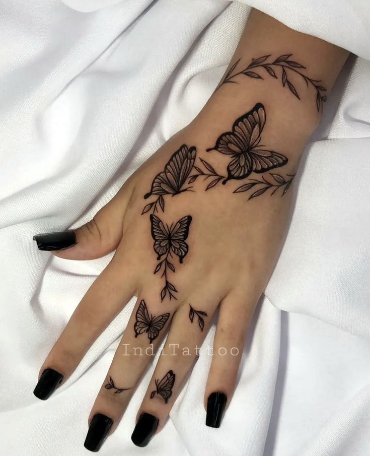 a woman's hand with butterflies on it