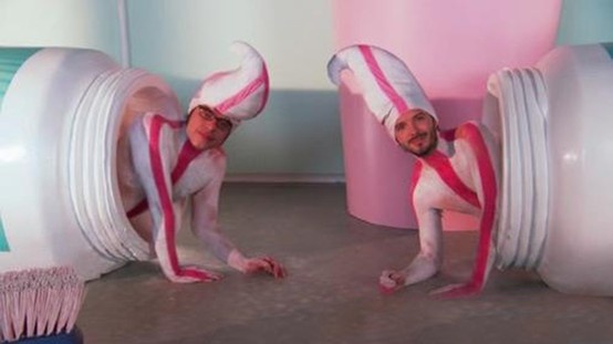 two men dressed in pink and white doing tricks