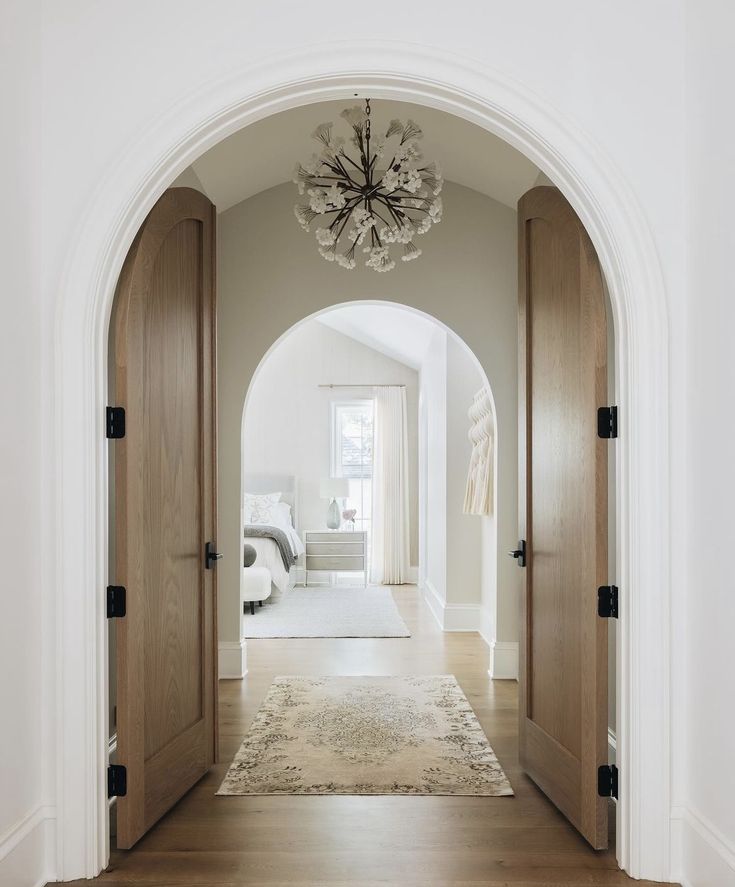 an archway leading to a bedroom with a chandelier hanging from the ceiling