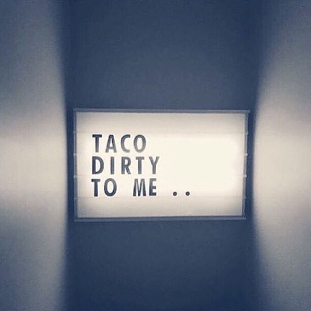 there is a sign that says taco dirty to me on the wall in an empty room