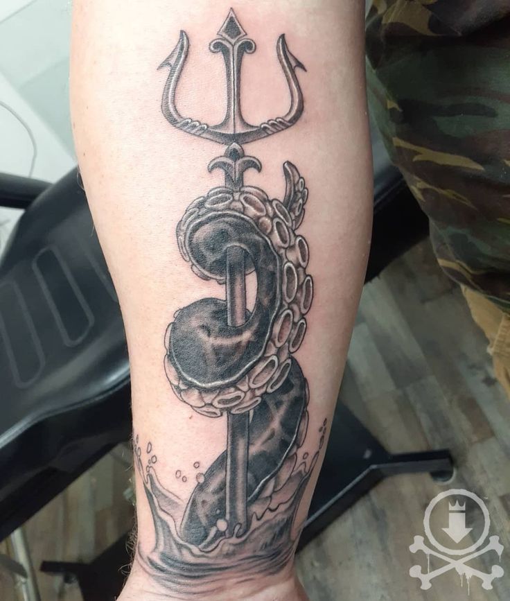 a black and white tattoo on the leg of a man with an anchor and chain