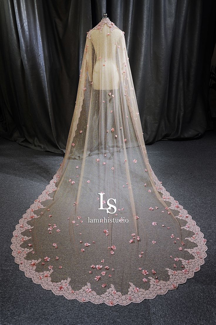 a wedding veil with pink flowers on it is displayed in front of a black backdrop