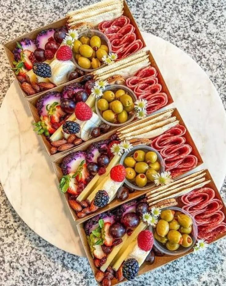 an assortment of food is displayed on a platter with utensils and olives