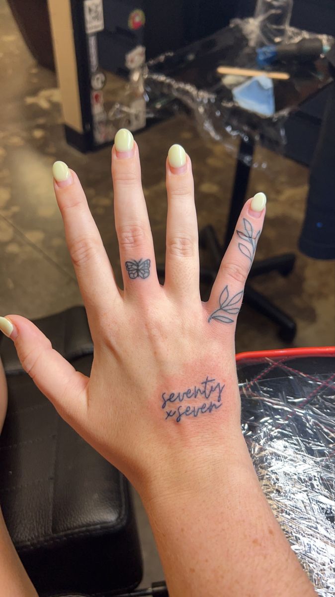 a woman's hand with tattoos on it and the words beauty is everywhere written on her fingers