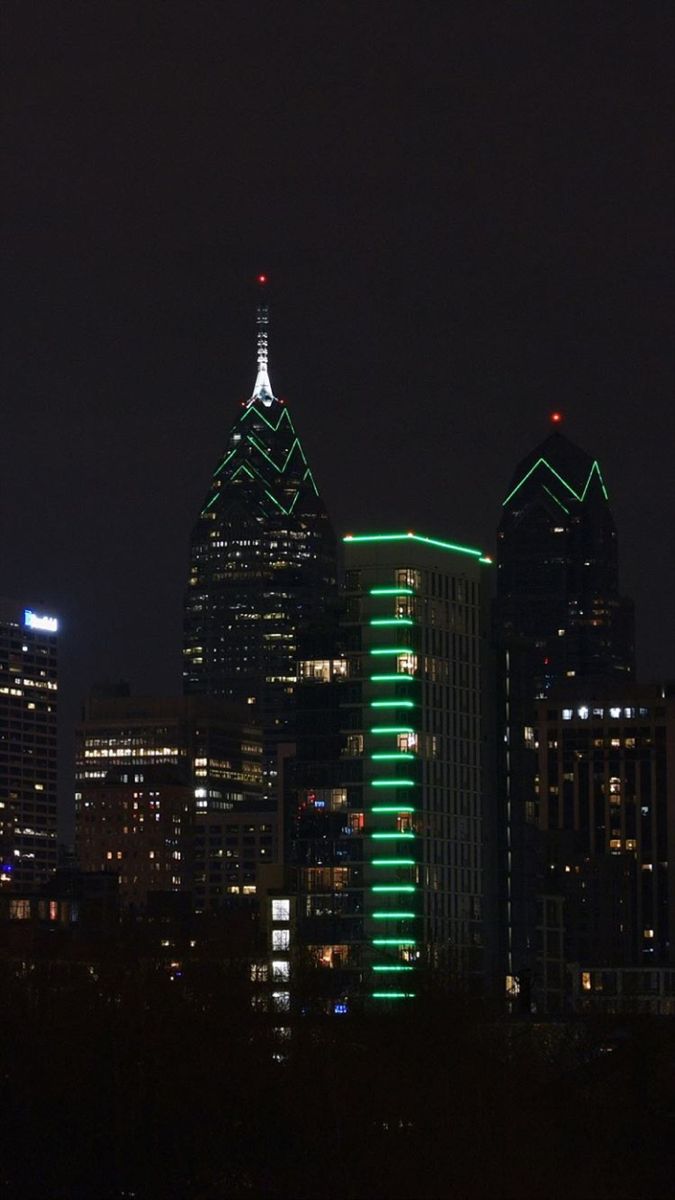 the city skyline is lit up in green for st patrick's day