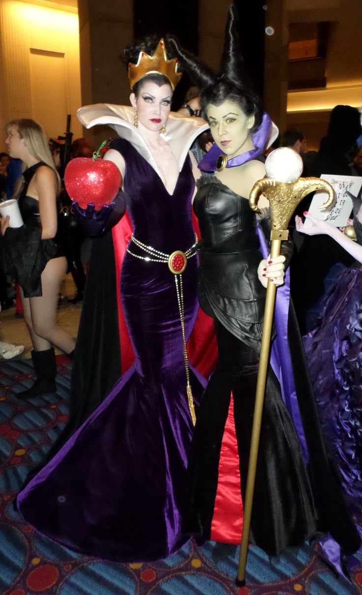 two women dressed up in costumes standing next to each other on a carpeted floor