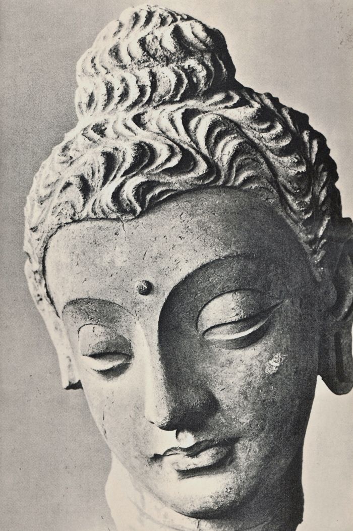 an old black and white photo of a buddha head