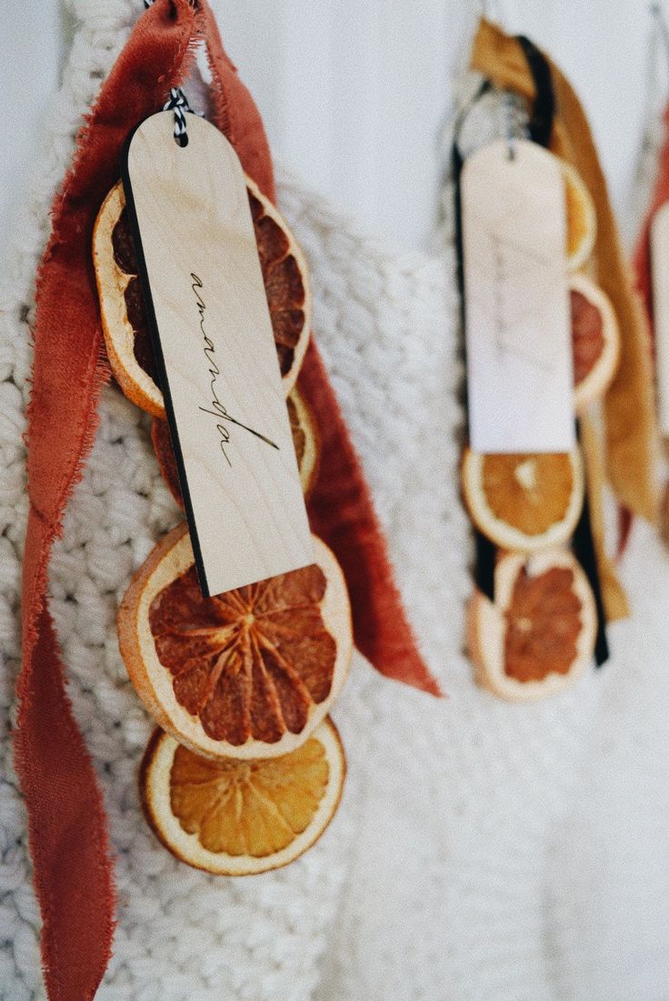 orange slices are hanging on the wall next to each other with tags attached to them