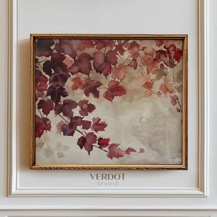 a painting hanging on the wall in front of a white frame with red and green leaves