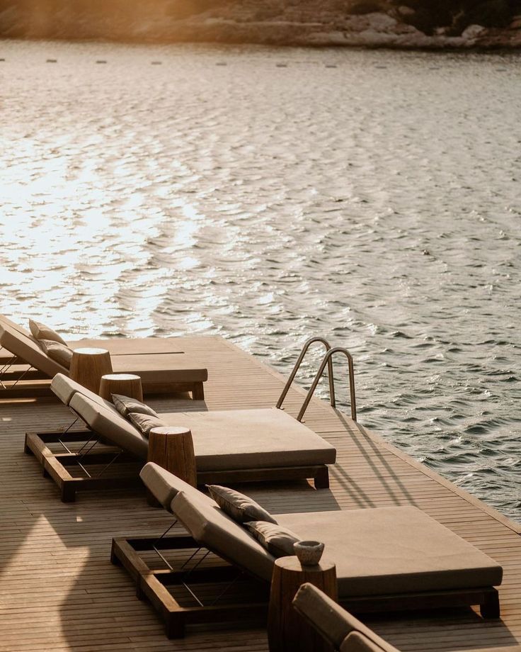 several lounge chairs on the edge of a dock