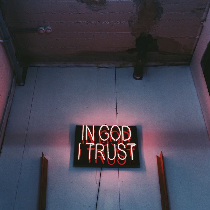 a neon sign that reads in god trust