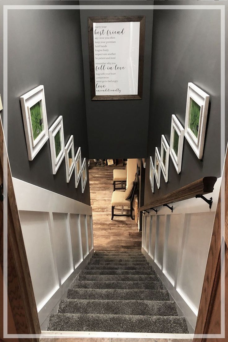 an open door leading to a hallway with pictures on the wall and carpeted stairs