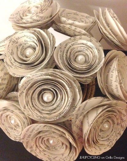 a bunch of rolled up books sitting on top of each other in the shape of flowers