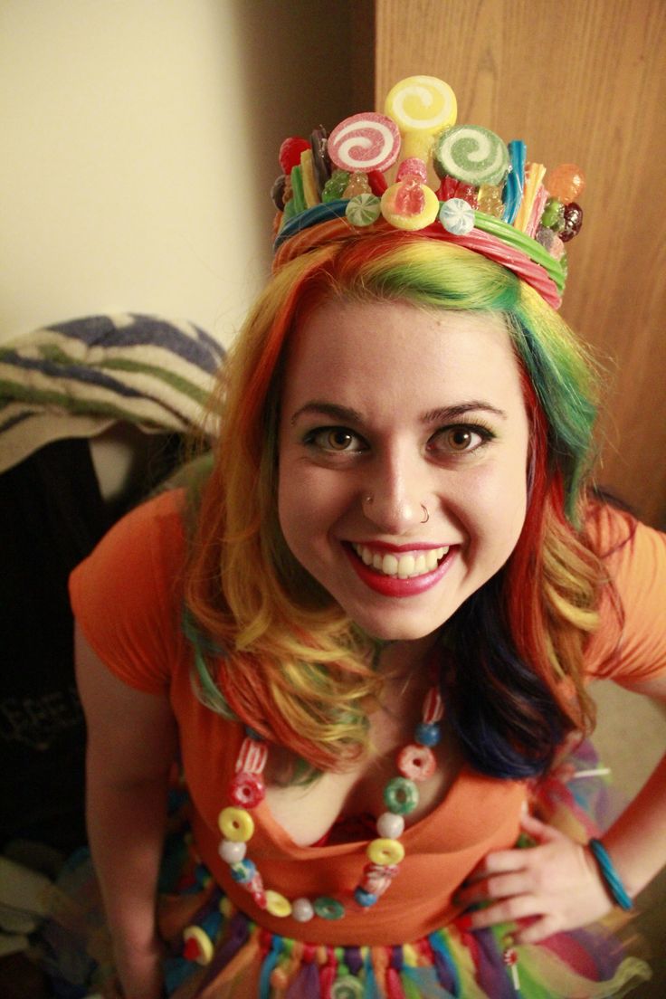 a girl with colorful hair and a crown on her head is smiling for the camera